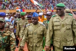 Members of a military council that staged a coup in Niger attend a rally at a stadium in Niamey on August 6.