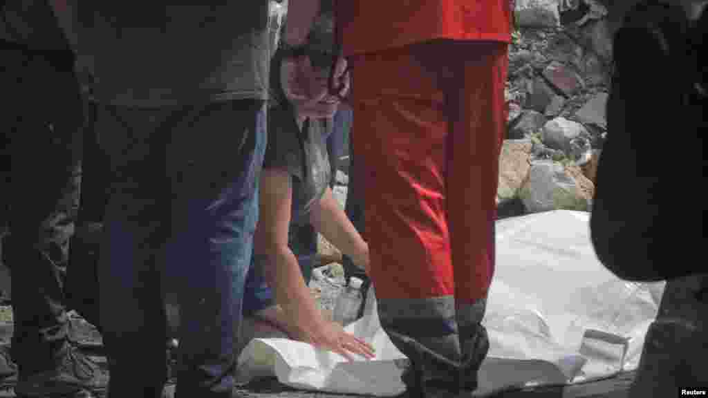 The mother reacts next to her son&#39;s body&nbsp;near a building that was heavily damaged by a Russian missile attack in central Odesa.