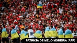 Dynamo Kyiv players enter the pitch wearing Ukrainian national flags during the UEFA Champions League playoff second leg soccer match against SL Benfica in Portugal on August 23, 2022.