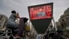 A big screen outside a shopping mall in Beijing shows Chinese President Xi Jinping speaking during an event to commemorate the 100th anniversary of China's Communist Party.