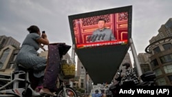 A big screen outside a shopping mall in Beijing shows Chinese President Xi Jinping speaking during an event to commemorate the 100th anniversary of China's Communist Party.