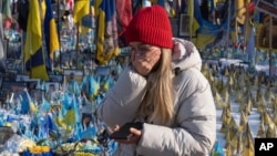 A woman cries at the memorial to the fallen Ukrainian soldiers on Independence Square in Kyiv on February 24.