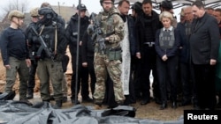 European Commission President Ursula von der Leyen, foreign policy chief Josep Borrell (second from right), and Slovak Prime Minister Eduard Heger (fourth from right) stand next to bodies that were exhumed from a mass grave as they visited the town of Bucha on April 8.