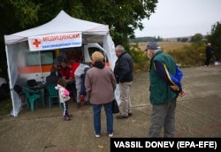 A small line of people forms to receive a vaccine against COVID-19 in the Bulgarian village of Krushovitsa.