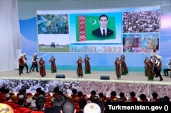 Dancers celebrate Harvest Day with a picture of Turkmen President Serdar Berdymukhammedov in the background. (file photo)