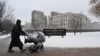 A woman pushes a pram past the U.S. Embassy in Kyiv on January 24. 