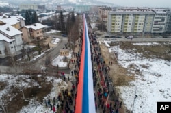 Bosnian Serbs carrying a giant Serbian flag march in Sarajevo on January 9.