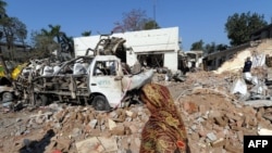  A resident walks past the wreckage from a deadly car bomb blast in Faisalabad on March 8.