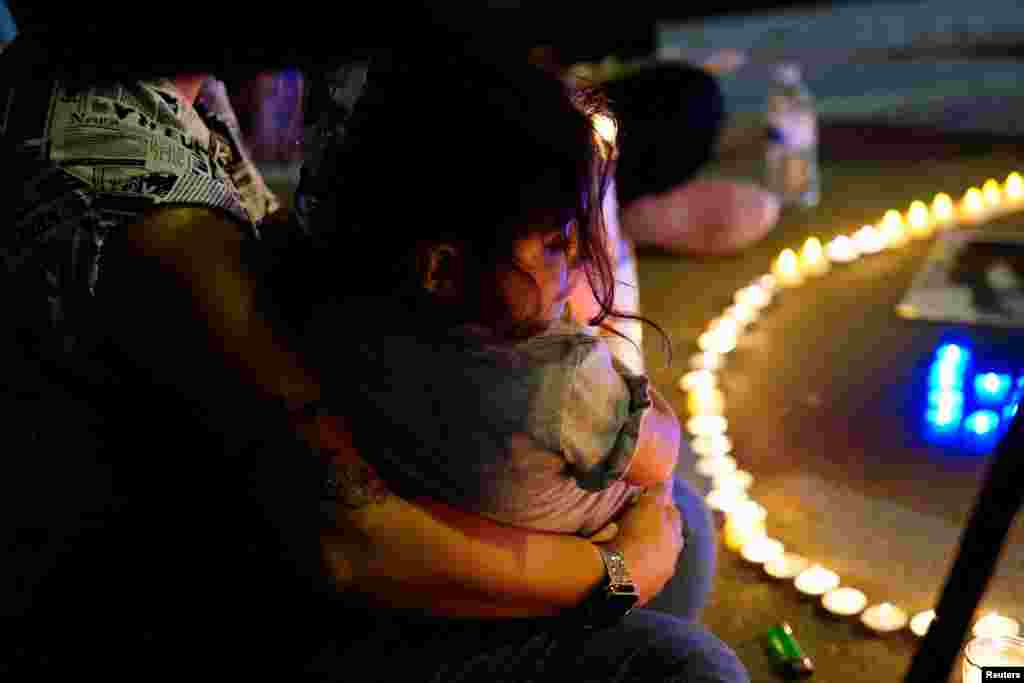 A woman cradles her daughter at a candlelit vigil protesting the death of Amini outside the Wilshire Federal Building in Los Angeles on September 22.