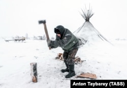 Ненецкий автономный округ. Оленевод рубит дрова для печи