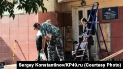 Workers repair damage at the site of a blast outside the national Pension Fund office in Kaluga on August 3. 