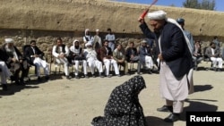 An Afghan judge hits a woman with a whip in front of a crowd in Ghor Province. (file photo)