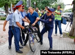 Police detain a man on a bicycle in Almaty. June 10, 2019