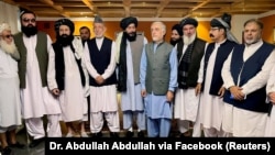 Former Afghan President Hamid Karzai (fifth left) and the ousted government's peace envoy, Abdullah Abdullah (fifth right), meet with members of the Taliban after the militants seized power in Kabul.