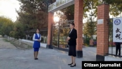 Teachers wait outside the gate of a school in the Tashkent region early on October 4.