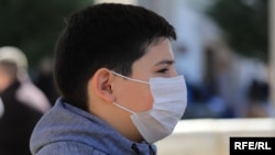 A child in Pristina wears a mask to protect against coronavirus.