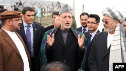 The onus is now on Afghan President Hamid Karzai (center) to stop surrounding himself with former warlords.