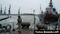 A Ukrainian serviceman stands on board a Coast Guard ship in the Sea of Azov port of Mariupol in eastern Ukraine on December 3.