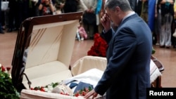 Ukrainian President Petro Poroshenko reflects at the coffin of journalist Pavel Sheremet, who was killed by a car bomb on July 20 in Kyiv. While condemning attacks on journalists, Poroshenko has also said journalists should not write "negative articles" about Ukraine.