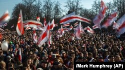 People wave old Belarusian republic flags during a rally commemorating the 1918 declaration of independence from Russia in Minsk on March 25.