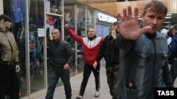 Young men near the scene in the Biryulevo neighborhood of Moscow on October 13 where gangs attacked a shopping center and clashed with police.