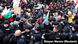 Protesters scuffle with police as they try to enter Bulgaria's parliament building during a rally in Sofia against government measures to curb the spread of the coronavirus on January 12. 