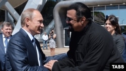 Russian President Vladimir Putin (left) talks to U.S. actor Steven Seagal while visiting the oceanarium on Russkiy island outside Vladivostok in September 2015.