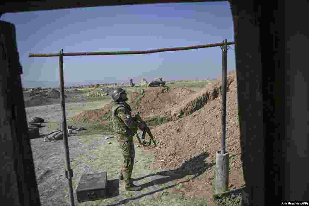 An Armenian soldier peers at the sky as a drone buzzes over the front lines on October 18.