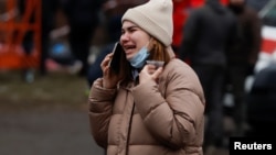 A woman weeps as emergency personnel work to rescue victims after an apartment block was heavily damaged by a Russian missile strike in Dnipro on January 15.