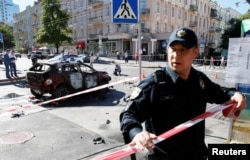 A police officer blocks off the site where journalist Pavel Sheremet was killed by a car bomb in central Kyiv on July 20.