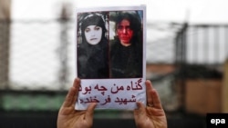 An Afghan demonstrator holds a placard reading in Dari "What was my sin?" with a picture of Farkhunda Malikzada, who was brutally murdered by a mob, during a protest against her killing outside the Supreme Court in Kabul in March 2015.