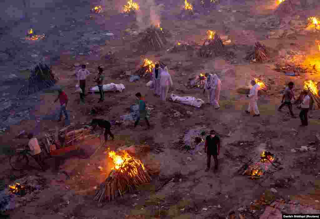 People wait to cremate COVID-19 victims at a crematorium in New Delhi on April 23.&nbsp;