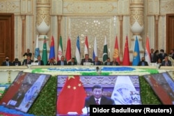 Participants listen to Chinese President Xi Jinping, who delivers a speech via a video link during the Shanghai Cooperation Organization (SCO) summit in the Tajik capital, Dushanbe, on September 17.