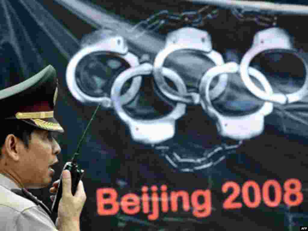 An Indonesian police officer stands beside an anti-Chinese banner during a demonstration organized by pro-Tibet activists and supporters during the Olympic torch&#39;s visit to Jakarta in April 2008.