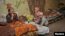 Residents sit in a basement used as a bomb shelter in Donetsk on December 30.