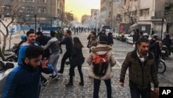 People are affected by tear gas fired by Iranian riot police to disperse protesters in Tehran on December 30. Since the protests erupted last week, the government has been blocking social media websites to disrupt the spread of information about the demonstrations. 