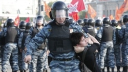 Russian riot police detain a female protester during an opposition protest in Moscow in May 2012.