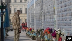 A serviceman pays his resepcts at the Memorial Wall of Fallen Defenders of Ukraine in Kyiv.