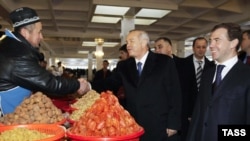 Uzbek President Islam Karimov (center) and his Russian counterpart, Dmitry Medvedev (right), visit a local market in Tashkent.