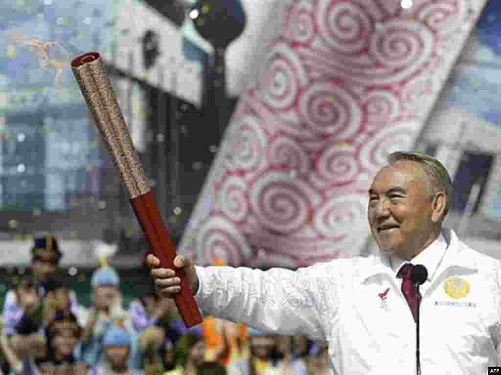 Kazakh President Nursultan Nazarbaev holds the Olympic torch at a stadium outside Almaty, the first stop after Beijing, in April 2008.