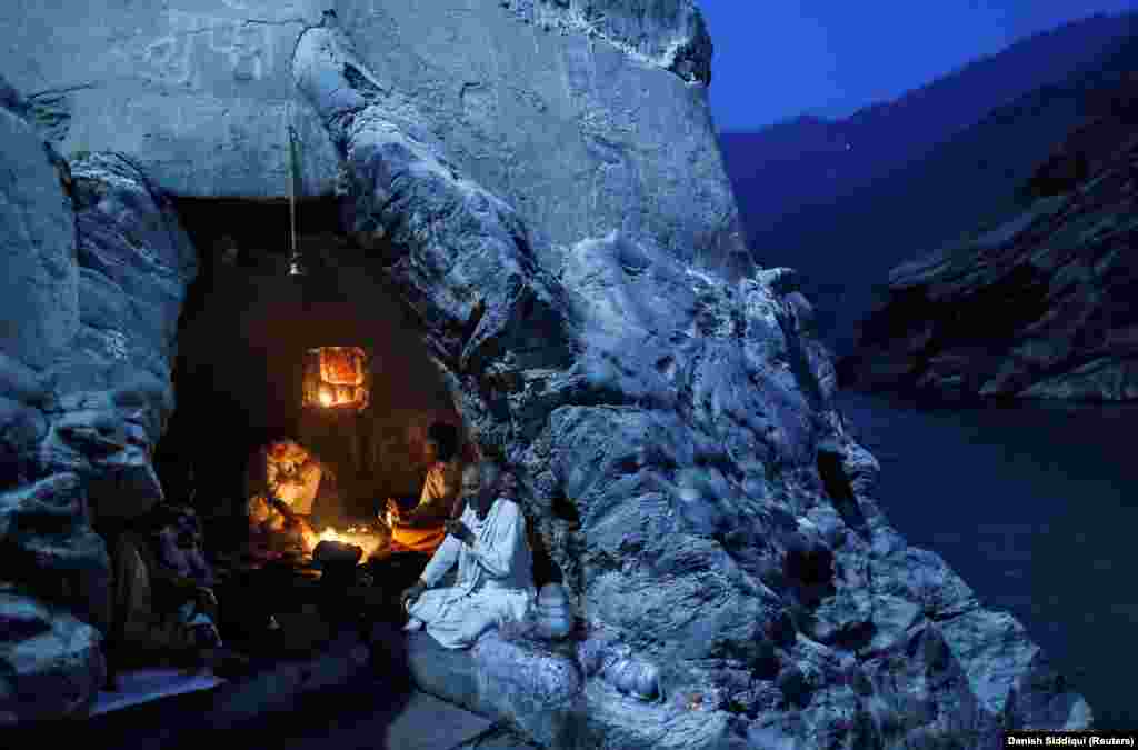 Hindu priests perform prayers in a cave on the banks of the River Ganges in Devprayag, India, on March 28, 2017.