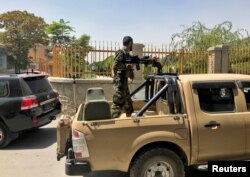 An Afghan soldier stands in a military vehicle on a street in Kabul on August 15.