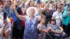 People holding European Union and Moldovan flags dance and sing in Chisinau in May at the end of a rally aiming to show the country's support for EU accession. 