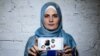 Mumine Saliyeva holding a picture of her imprisoned husband and their four children.