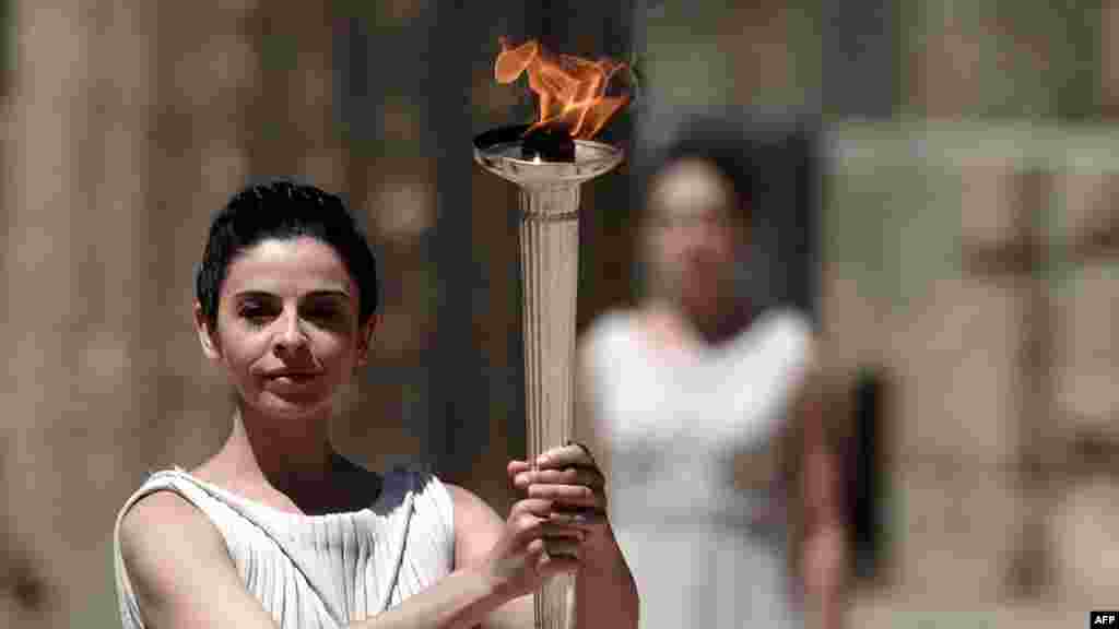 Actress Ino Menegaki, playing the role of high priestess, holds up the Olympic flame during a dress rehearsal for the torch-lighting ceremony of the London 2012 Olympic Games at the site of ancient Olympia on May 9.